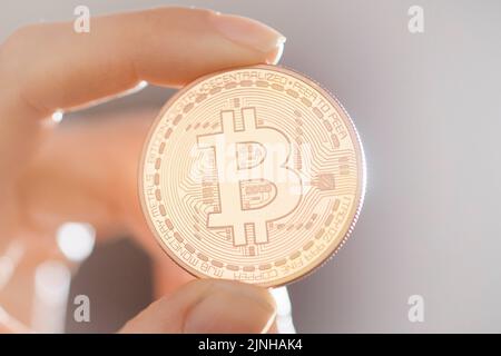 Berlino, Germania. 10th Mar, 2022. Foto simbolica sul tema di Bitcoin - valuta virtuale. Una moneta bitcoin è tenuta in una mano. Berlino, 10 marzo 2022 Credit: dpa/Alamy Live News Foto Stock