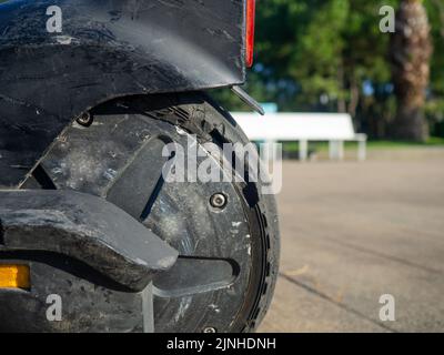 Parte di un primo piano di uno scooter elettrico. Pneumatico rotto. Ruota dello scooter rotta. Attrezzo di propulsione. Veicoli per il divertimento Foto Stock