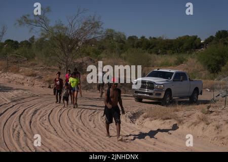 Eagle Pass, Texas, Stati Uniti. 11th ago, 2022. I migranti sono scortati dalle forze dell'ordine su una strada sterrata dopo aver attraversato illegalmente il fiume Rio Grande dal Messico all'Eagle Pass, Texas, giovedì 11 agosto 2022. (Credit Image: © Allison Dinner/ZUMA Press Wire) Foto Stock