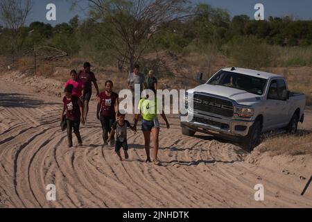 Eagle Pass, Texas, Stati Uniti. 11th ago, 2022. I migranti sono scortati dalle forze dell'ordine su una strada sterrata dopo aver attraversato illegalmente il fiume Rio Grande dal Messico all'Eagle Pass, Texas, giovedì 11 agosto 2022. (Credit Image: © Allison Dinner/ZUMA Press Wire) Foto Stock