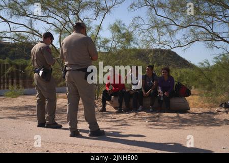 Eagle Pass, Texas, Stati Uniti. 11th ago, 2022. I migranti attendono con gli ufficiali del Texas DPS per la pattuglia di confine degli Stati Uniti dopo aver attraversato illegalmente il fiume Rio Grande dal Messico all'Eagle Pass, Texas, giovedì 11 agosto 2022. (Credit Image: © Allison Dinner/ZUMA Press Wire) Foto Stock