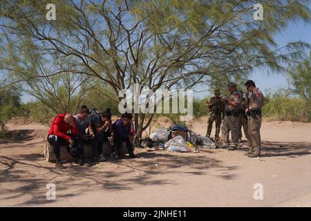 Eagle Pass, Texas, Stati Uniti. 11th ago, 2022. I migranti attendono con gli ufficiali del Texas DPS per la pattuglia di confine degli Stati Uniti dopo aver attraversato illegalmente il fiume Rio Grande dal Messico all'Eagle Pass, Texas, giovedì 11 agosto 2022. (Credit Image: © Allison Dinner/ZUMA Press Wire) Foto Stock
