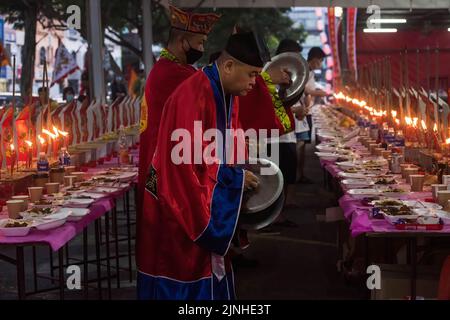 Kuala Lumpur, Kuala Lumpur, Malesia. 8th ago, 2022. I sacerdoti etnici cinesi offrono preghiere davanti alle offerte per gli spiriti durante il festival dei fantasmi affamati a Kota Damansara a Kuala Lumpur. Il festival dei fantasmi affamati cade il 15th° giorno del settimo mese lunare. I devoti cinesi credevano che le porte dell'inferno fossero aperte durante il mese e gli antenati morti ritornavano sulla Terra. (Credit Image: © Vivian lo/SOPA Images via ZUMA Press Wire) Foto Stock