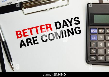 Sul tavolo ci sono gli ingranaggi, le matite e un quaderno con l'iscrizione - i giorni migliori stanno per arrivare. Foto Stock