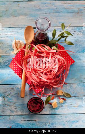 Tagliatelle di Barolo, parmigiano, aglio, pomodoro pesto e bottiglia di vino rosso Foto Stock