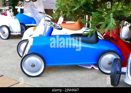 toddler taglia blu sport auto sotto l'albero Foto Stock