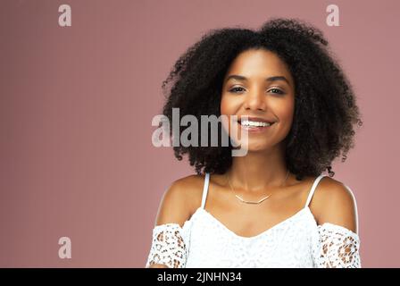 La felicità è sempre di moda, una bella giovane donna che sorride su uno sfondo rosa. Foto Stock