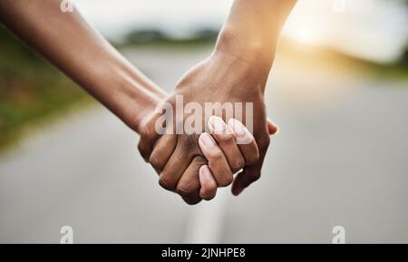 Il viaggio della vita è migliore se condiviso con un partner. Primo piano di una coppia irriconoscibile che tiene le mani insieme all'aperto. Foto Stock