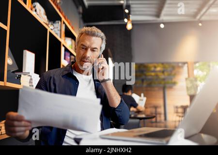 Ive mi ha dato la relazione in mano mentre parliamo, un bel uomo d'affari maturo che lavora nel suo internet café locale. Foto Stock