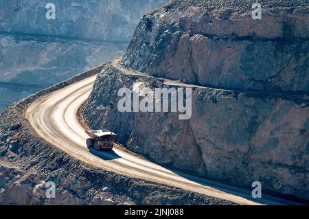 Camion di minerale sulla strada nella miniera d'oro Kalgoorlie super-pit nell'Australia occidentale, i camion di miniera hanno un tempo di un'ora per scendere o guidare dal fondo della fossa. Foto Stock