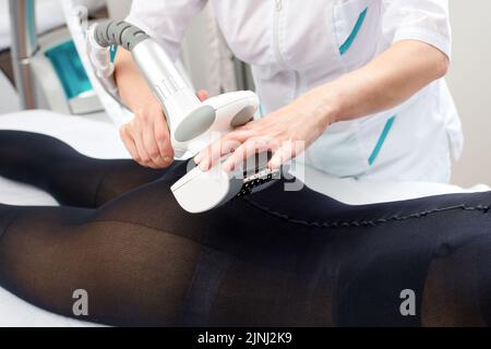 La donna riceve il massaggio GPL per rimuovere la cellulite dal corpo, per sollevare le gambe. Concetto di terapia di bellezza nel salone termale. Foto Stock