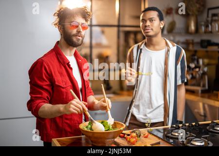 Due ragazzi cucinano sano insieme a casa Foto Stock