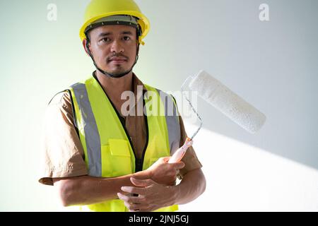 Gli uomini dipingono il colore degli interni con la pittura a rullo su sfondo bianco Foto Stock