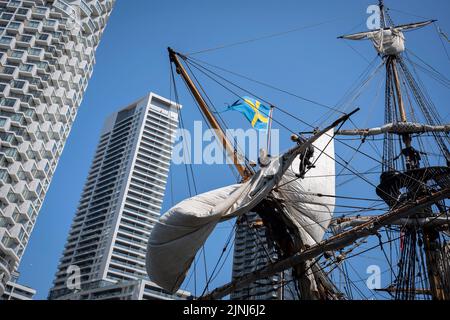 L'equipaggio della nave a vela replica, Goteborg, effettua riparazioni e manutenzione mentre attraccato sotto le alte torri di South Quay, Canary Wharf nei Docklands di Londra, durante la sua visita di quattro giorni alla capitale prima di continuare la sua spedizione di due anni intorno al mondo a Shanghai, Cina, il 9th agosto 2022, A Londra, Inghilterra. I londinesi sono invitati a visitare i ponti di questo facsimile della nave originale che affondò al largo della costa svedese nel 1745. Il suo carico principale sarebbe stato il tè, porcellana, erbe e seta sulla rotta della Cina. Foto Stock