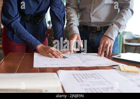 Un gruppo di manager di talento si è riunito in sala riunioni e ha partecipato al brainstorming su progetti congiunti, documenti giacenti su tavoli di legno Foto Stock