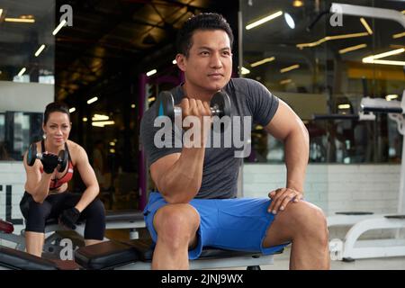 Giovani vietnamiti che lavorano insieme in palestra Foto Stock