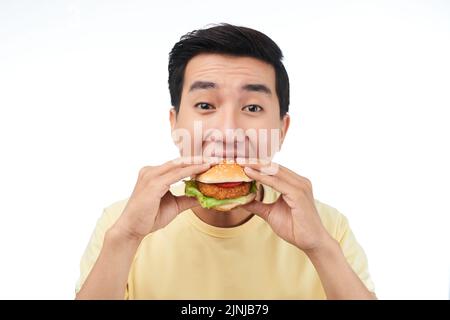 Giovane amante del fast food che mangia hamburger di pollo Foto Stock