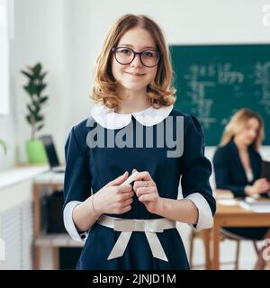 Ritratto di una bambina sorridente con gesso in mano in classe. Foto Stock