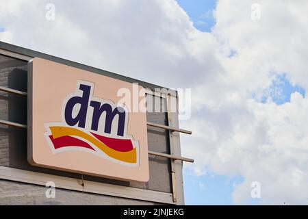 Un primo piano di un cartellone del dm farmacia contro un cielo blu nuvoloso Foto Stock