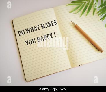 Fai ciò che ti rende felice simbolo. Notebook con le parole "fate quello che vi rende felici". Affari, faccia che cosa li rende concetto felice Foto Stock