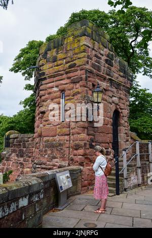 Chester, Regno Unito: 3 luglio 2022: Una donna turistica legge un cartello informativo adiacente alla Water Tower sulle storiche mura romane di Chester Foto Stock