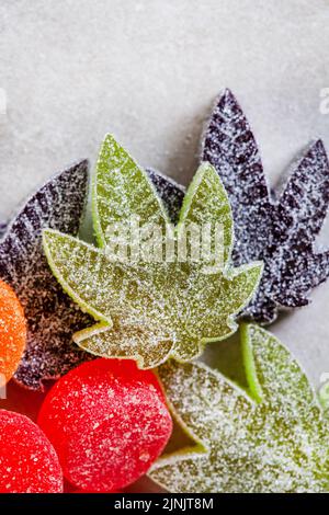 CBD e Cannabis infondono caramelle di gelatina su superficie grigia con spazio di copia Foto Stock