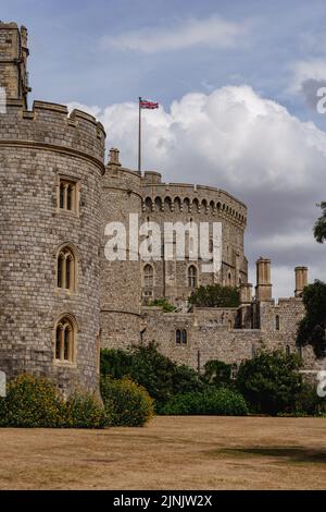 Windsor, Regno Unito - 2022 agosto: La Torre rotonda al Castello di Windsor con la bandiera dell'Unione che oscura nel vento Foto Stock