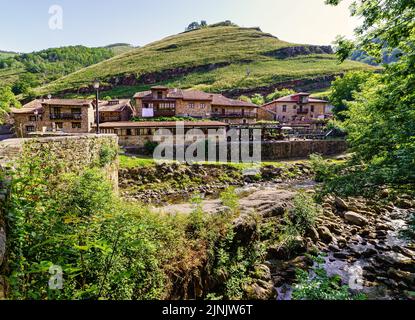 Ruscello che passa accanto a una vecchia città di montagna. Barcena Mayor Santander. Foto Stock