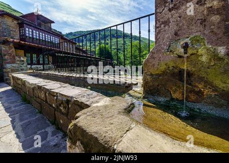 Sorgente di acqua cristallina nel vecchio villaggio di case di pietra. Barcena Mayor Santander. Foto Stock