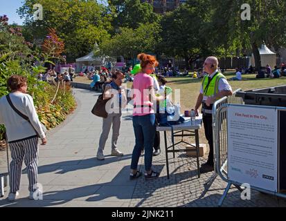 St Andrew's Square, Edimburgo, Scozia, Regno Unito. 12th agosto 2022. Film Festival cinema gratuito con Paddigton Bear il primo film che mostra per un piccolo pubblico. Temperatura 21 gradi centigradi. Nella foto: Controllo di sicurezza delle borse delle persone quando entrano nei giardini. Credit: Arch White/alamy live news. Foto Stock