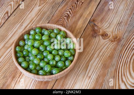 Frutti di bosco maturi in ciotola su tavola di legno. Raccolta delle bacche. Foto Stock