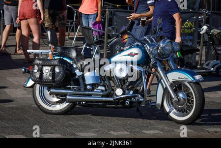 Una moto classica Harley Davidson Heritage Softail in blu, parcheggiata all'esterno di un bar Foto Stock