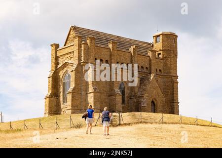 Siccità Regno Unito 2022; due donne che camminano fino a St Catherines Chapel, Abbotsbury Dorset, attraverso campi di erba arida, estate 2022 agosto Inghilterra del Sud Foto Stock