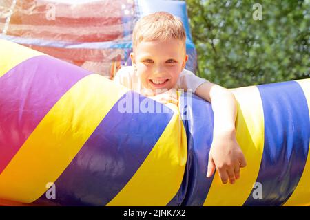 Ragazzo felice sul trampolino gonfiabile.concetto di divertimento della famiglia. Foto Stock