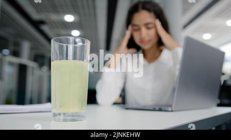 Giovane donna stanca manager si siede in ufficio sente mal di testa soffre di dolore lavoro eccessivo ragazza malsana ufficio lavoratore sensazione di malessere pressione emicrania Foto Stock