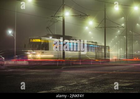 Un tram a Bucarest, Romania, in una notte di nebbia presa con lunga esposizione Foto Stock