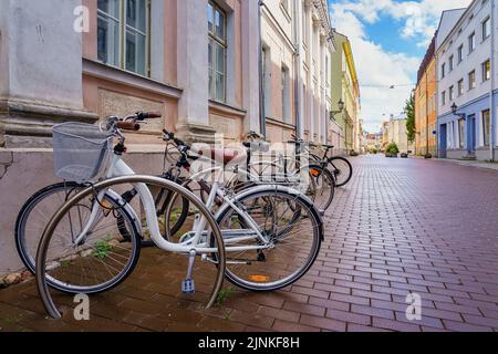 Biciclette parcheggiate sulla strada acciottolata nella città di Tartu Estonia. Foto Stock