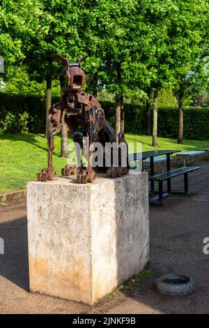 Uno scatto verticale di una statua metallica di un cane su un plinto di pietra nella tenuta del castello di Blaise, Bristol Foto Stock