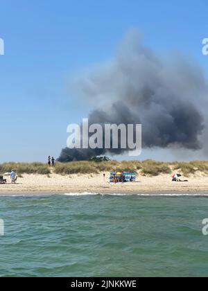 Foto dell'handout pubblicata da Nina Ross di fumo nero pesante che sale dalla scena su Studland Heath, Dorset, come una siccità è stata dichiarata per parti dell'Inghilterra dopo l'estate più secca per 50 anni. Data immagine: Venerdì 12 agosto 2022. Foto Stock