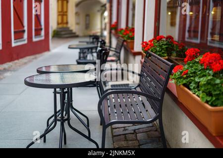 Terrazza con tavoli rotondi in vetro e sedie in metallo per rilassarsi e sorseggiare un drink. Foto Stock