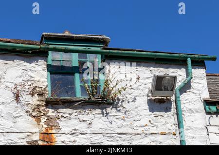 Un edificio colorato (molto di carattere). Finestre rotte, piante, macchie di ruggine, pietra esposta. Tutte le finestre sono diverse. Meraviglioso... Foto Stock