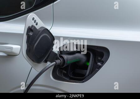 Auto elettrica che carica l'elettricità con una porta nera Foto Stock