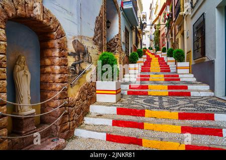 Vicolo stretto decorato con la bandiera di Spagna sulla scalinata. Calpe Alicante. Foto Stock