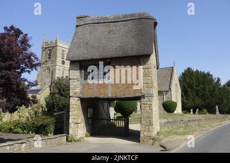 St Peter & St Paul Church Long Compton risale al 13th ° secolo con la sua insolita Lynch Gate che passa sotto un vecchio cottage in paglia è stato estesamente Foto Stock