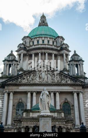 Belfast, Regno Unito – 30 ottobre 2019 – Monumento alla Regina Vittoria di fronte alla cupola in stile barocco del Municipio di Belfast Foto Stock