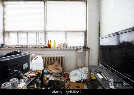 Un soggiorno appartamento sporco con un sacco di ammasso all'interno di un appartamento di un hoarder. Questo edificio è stato da allora demolito Foto Stock
