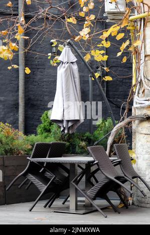 Ombrello chiuso e sedie impilate di strada caffè in Ucraina Kiev Foto Stock