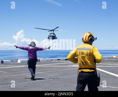 I marinai della Marina statunitense assegnati alla USS New Orleans (LPD 18) si preparano per un corpo marino statunitense UH-1Y Huey a atterrare a bordo della USS New Orleans, nel Mare delle Filippine, 5 agosto 2022. Il col. E Sgt. Major visitò la LPD per verificare il benessere dei Marines e dei marinai. Il MEU 31st opera a bordo delle navi del Tripoli Amphibious Ready Group nell'area delle flotte 7th per migliorare l'interoperabilità con alleati e partner e servire come pronta forza di risposta per difendere la pace e la stabilità nella regione Indo-Pacifico. (STATI UNITI Corpo marino foto di Lance CPL. Yvonne Iwae) Foto Stock