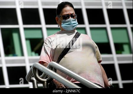 New York, Stati Uniti. 12th ago, 2022. Una donna indossa una maschera protettiva quando entra nella stazione della metropolitana Bowling Green a Lower Manhattan, New York, NY, 12 agosto 2022. I Centri per il controllo delle malattie (CDC) hanno annunciato una revisione delle linee guida che includono il non screening delle persone senza sintomi, l'aggiornamento dei protocolli scolastici e la necessità di non indossare una maschera dopo cinque giorni di quarantena e test negativi il 6th e 8th giorno; Il CDC ha sottolineato la responsabilità personale e la scelta di fronte al COVID-19 che continua a diffondersi negli Stati Uniti nelle sue varianti. (Foto di Anthony Behar/Sipa USA Foto Stock