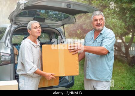 Coppia senior scatola di trasporto da auto a nuova casa. In movimento Foto Stock